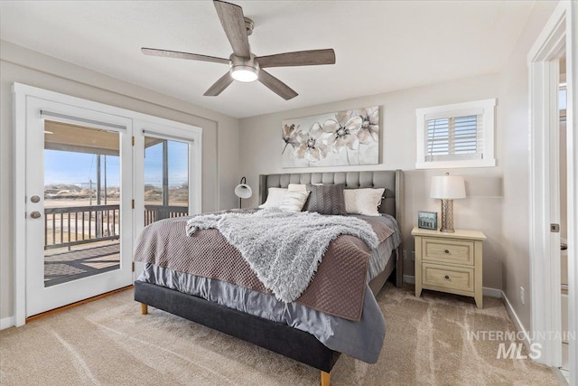bedroom with multiple windows, light colored carpet, and access to outside
