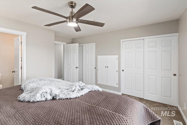 bedroom featuring a ceiling fan, visible vents, baseboards, carpet floors, and two closets