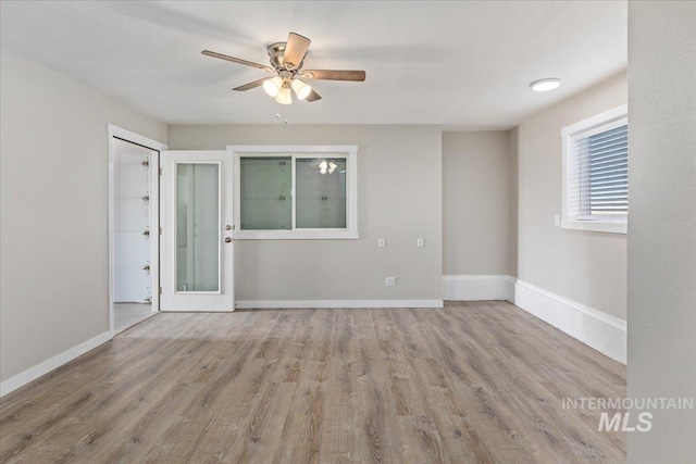 empty room with light wood-style flooring, baseboards, and ceiling fan