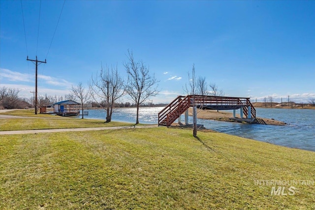 dock area with a yard and a water view
