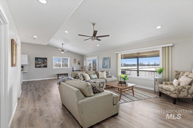 living area with wood finished floors, recessed lighting, baseboards, ceiling fan, and vaulted ceiling