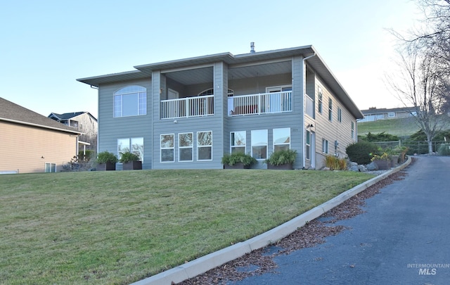 exterior space with a balcony and a front lawn