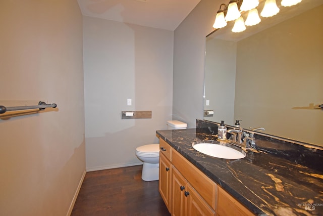 bathroom with hardwood / wood-style flooring, toilet, and vanity