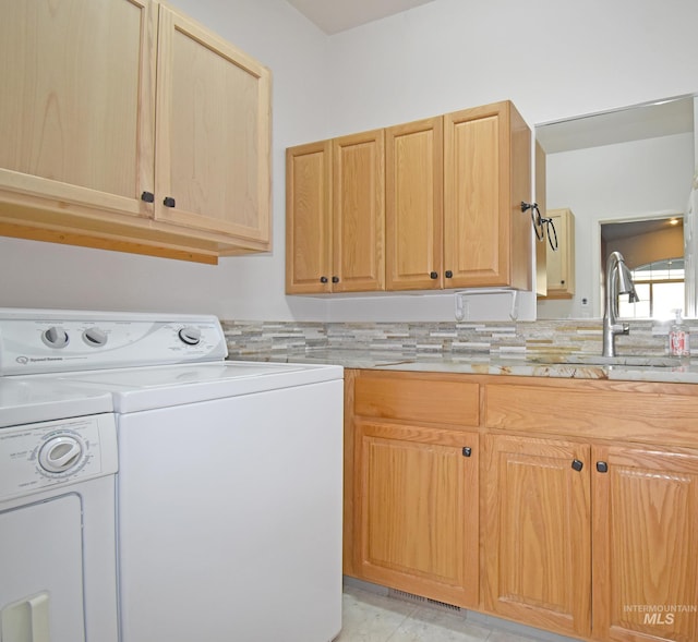 washroom featuring sink, washer and clothes dryer, and cabinets