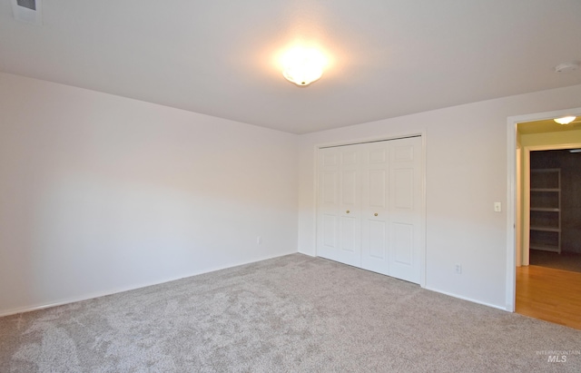 unfurnished bedroom with a closet and carpet floors