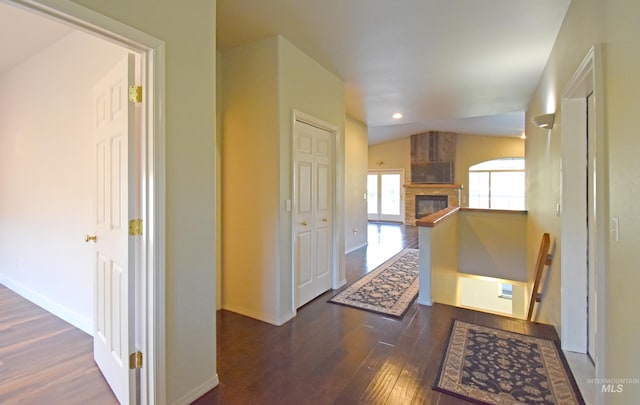 corridor featuring vaulted ceiling and dark wood-type flooring