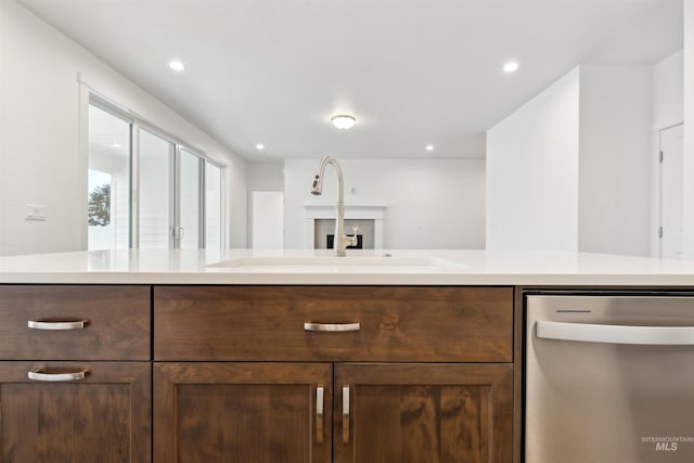 kitchen with a sink, stainless steel dishwasher, recessed lighting, and light countertops