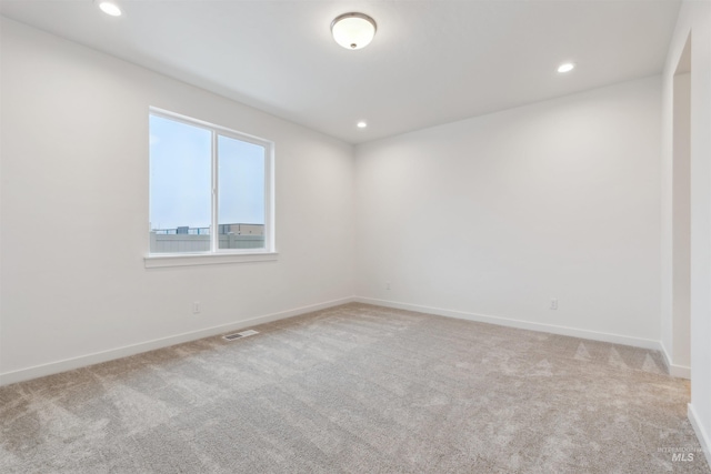 carpeted empty room with recessed lighting, visible vents, and baseboards