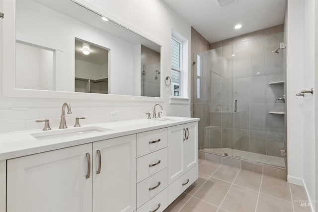 full bathroom featuring a shower stall, double vanity, tile patterned floors, and a sink