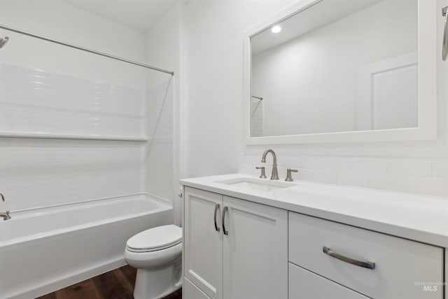 bathroom with vanity, toilet, wood finished floors, and shower / bathtub combination