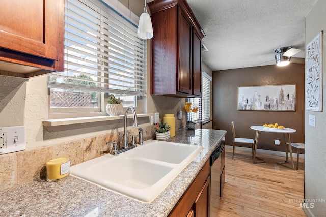 kitchen with sink, light wood-type flooring, dishwasher, a textured ceiling, and ceiling fan