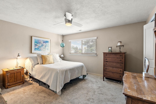 carpeted bedroom featuring a textured ceiling and ceiling fan