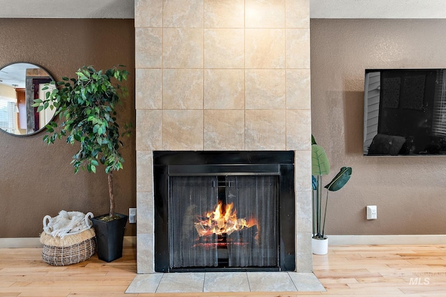 room details with hardwood / wood-style floors and a tile fireplace