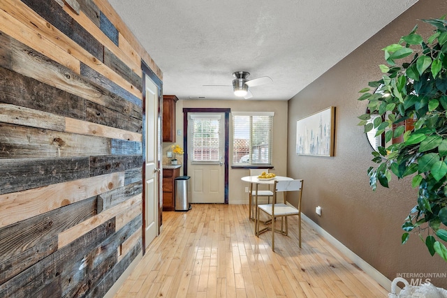 interior space featuring a textured ceiling, light wood-type flooring, and ceiling fan