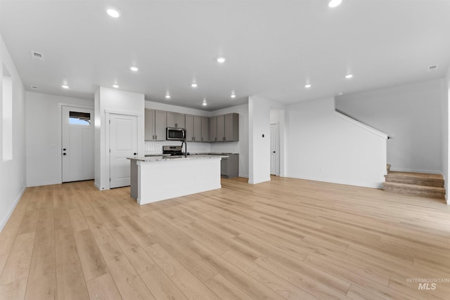 690 N Tessa Ave, Meridian, ID 83642 - kitchen with stainless steel appliances, gray cabinets, light wood-style floors, open floor plan, and recessed lighting