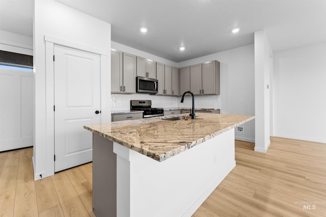 690 N Tessa Ave, Meridian, ID 83642 - kitchen with appliances with stainless steel finishes, a sink, gray cabinetry, light stone counters, and light wood-style floors