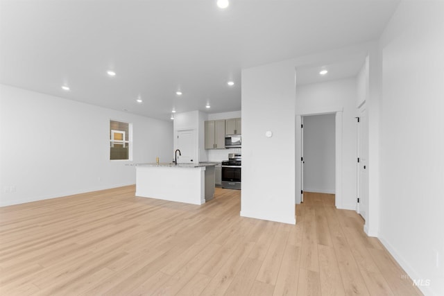 690 N Tessa Ave, Meridian, ID 83642 - kitchen with stainless steel appliances, gray cabinets, an island with sink, light wood-type flooring, and open floor plan