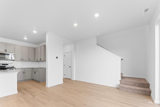 690 N Tessa Ave, Meridian, ID 83642 - kitchen featuring stainless steel appliances, gray cabinets, light wood-type flooring, decorative backsplash, and baseboards
