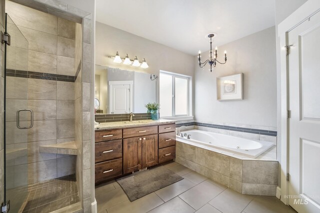 2858 Sunray Loop, Twin Falls, ID 83301 - full bath featuring a whirlpool tub, vanity, a stall shower, a chandelier, and tile patterned flooring