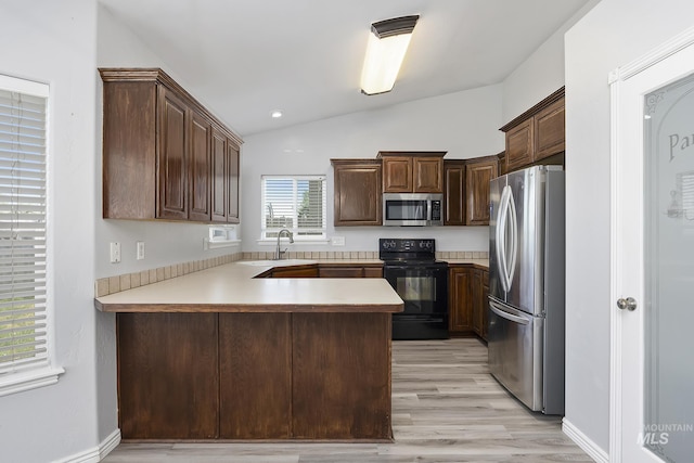 1030 Caswell Ave W, Twin Falls, ID 83301 - kitchen featuring appliances with stainless steel finishes, a peninsula, lofted ceiling, light wood-style flooring, and light countertops