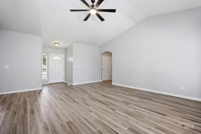 1030 Caswell Ave W, Twin Falls, ID 83301 - unfurnished living room featuring ceiling fan, arched walkways, wood finished floors, and high vaulted ceiling
