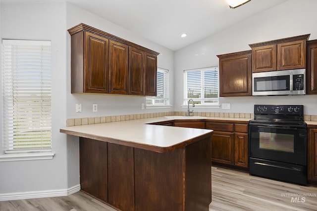 1030 Caswell Ave W, Twin Falls, ID 83301 - kitchen featuring stainless steel microwave, black electric range, light wood-type flooring, light countertops, and lofted ceiling