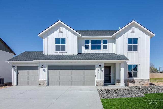 modern inspired farmhouse with concrete driveway, board and batten siding, stone siding, and a shingled roof