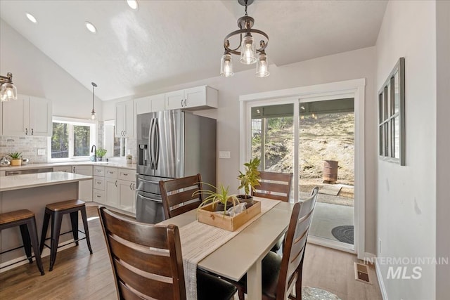 dining area with dark wood finished floors, recessed lighting, and high vaulted ceiling
