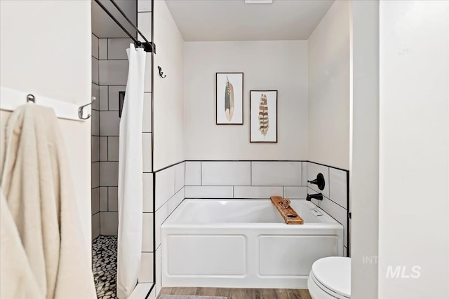 bathroom with tile walls, a garden tub, toilet, and a shower stall