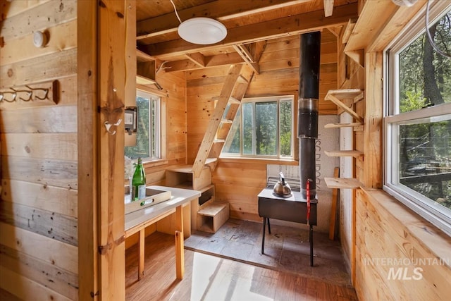 bathroom with wood-type flooring, healthy amount of natural light, and wood walls