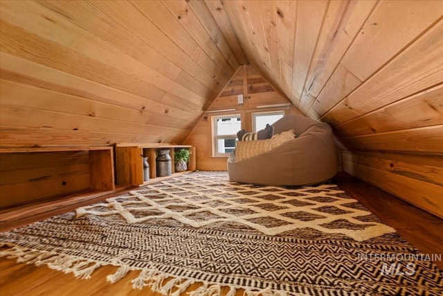 additional living space with wooden walls, wood ceiling, wood finished floors, and vaulted ceiling