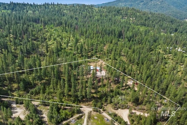 aerial overview of property's location featuring a heavily wooded area, mountains, and property parcel outlined
