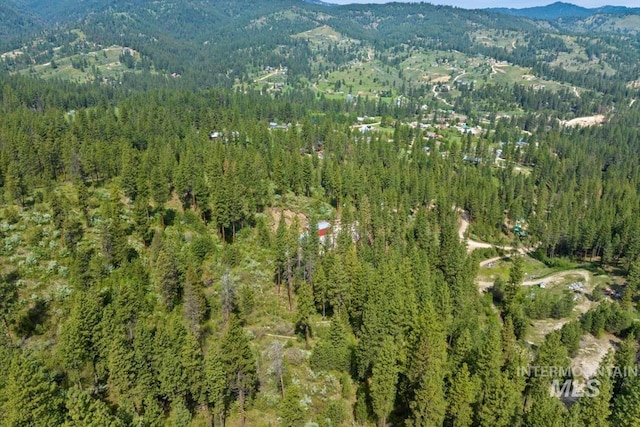 view of property location with a heavily wooded area and mountains