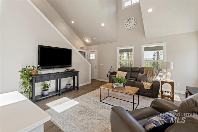 living area with high vaulted ceiling, plenty of natural light, baseboards, wood finished floors, and recessed lighting