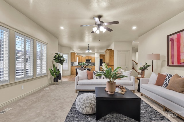 living room with baseboards, visible vents, recessed lighting, ceiling fan, and light colored carpet