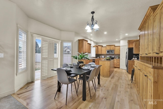 dining space with recessed lighting, light wood-style flooring, a healthy amount of sunlight, and a chandelier