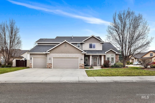 traditional-style house featuring an attached garage, a front lawn, fence, stone siding, and driveway