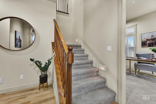 stairs featuring wood finished floors and baseboards