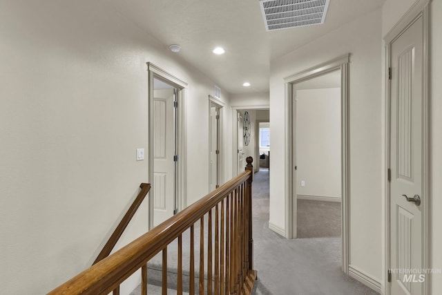 hall featuring visible vents, baseboards, an upstairs landing, carpet flooring, and recessed lighting