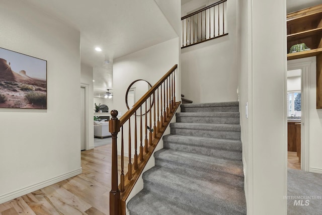 stairway with recessed lighting, baseboards, and wood finished floors