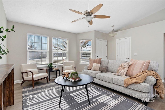 living room featuring lofted ceiling, ceiling fan, dark hardwood / wood-style flooring, and a healthy amount of sunlight