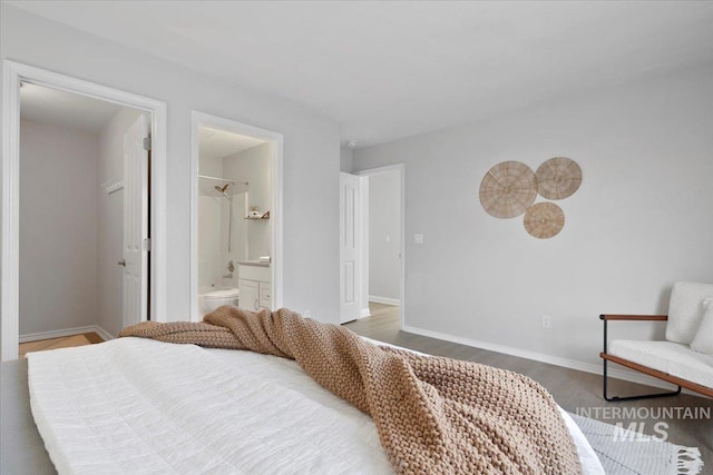 bedroom with wood-type flooring and connected bathroom