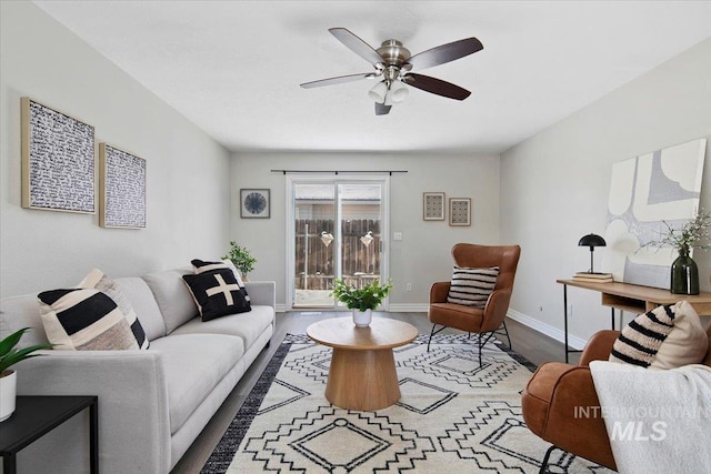 living room featuring dark wood-type flooring and ceiling fan