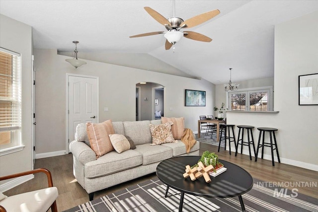 living room with ceiling fan, dark hardwood / wood-style floors, and vaulted ceiling