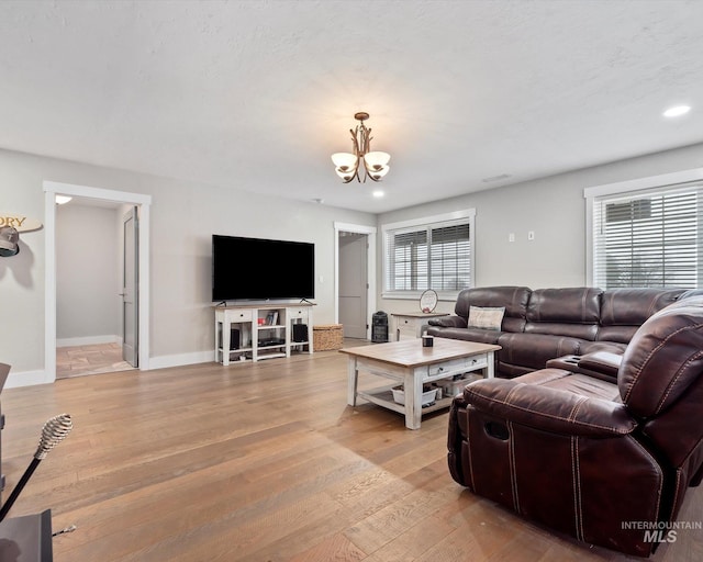 living room featuring light hardwood / wood-style floors and a notable chandelier