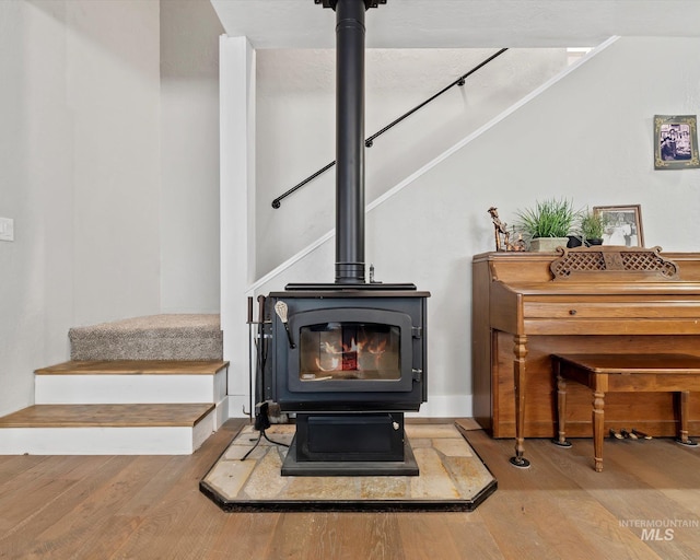 room details with a wood stove and hardwood / wood-style floors