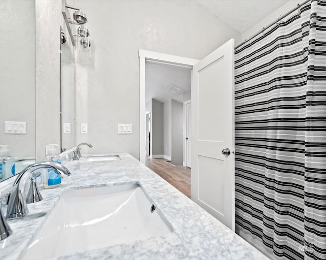 bathroom with curtained shower, wood-type flooring, and vanity