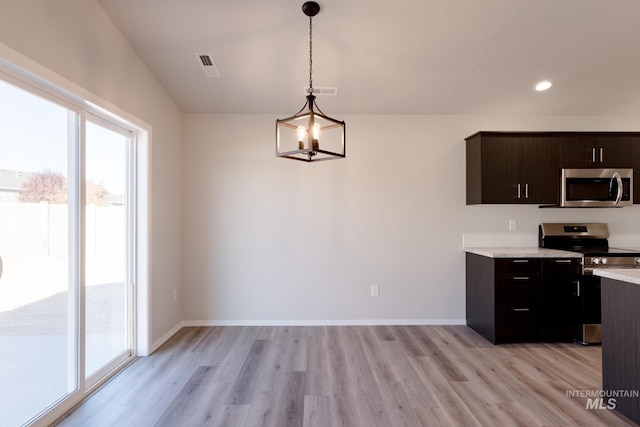 kitchen featuring light countertops, stainless steel appliances, visible vents, and light wood-style floors