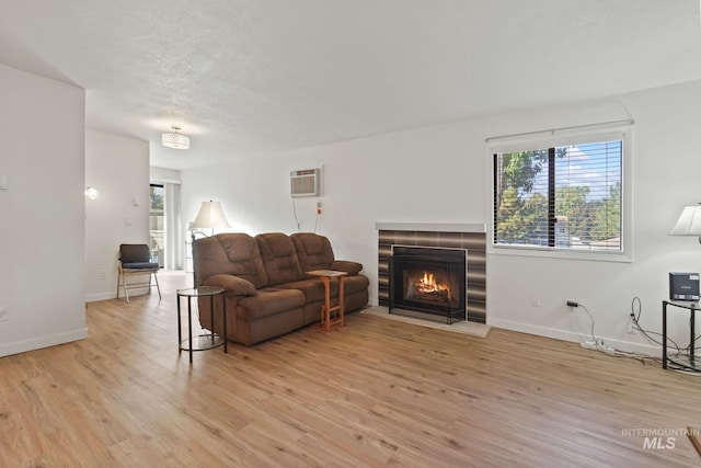 living room featuring light wood-type flooring and a wall mounted AC