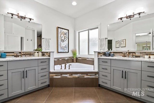 356 E Lake Briar Ln, Eagle, ID 83616 - bathroom with two vanities, tile patterned floors, a garden tub, backsplash, and recessed lighting